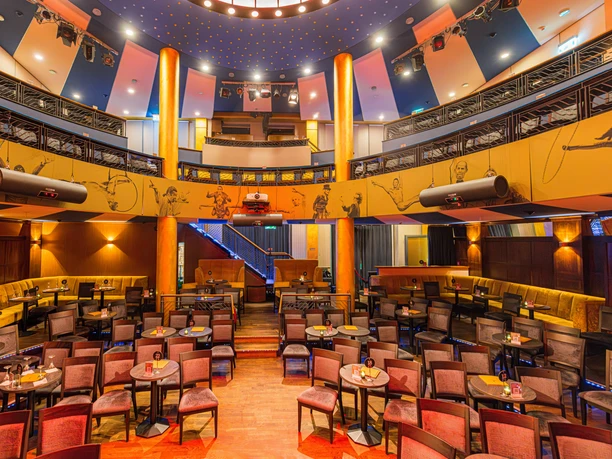 Varietésaal im Krystallpalast Varieté Leipzig - Abendveranstaltungen in Leipzig Blick in den Varietésaal des Krystallpalast Varieté Leipzig mit zahlreichen Stühlen, Tischen und Sitzecken bei heller Beleuchtung, Kultur, Abendveranstaltung