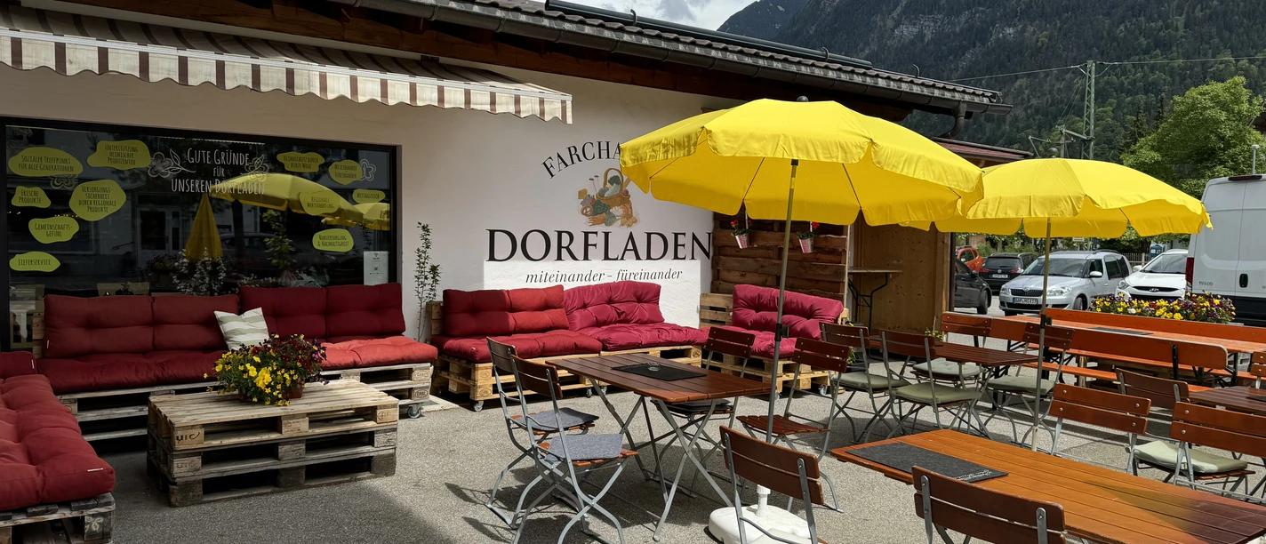 Dorfladen_Farchant_c_Tourist-Information_Farchant.jpg Tische mit Sonnenschirmen und bequeme Sitzmöglichkeiten direkt vor dem Dorfladen