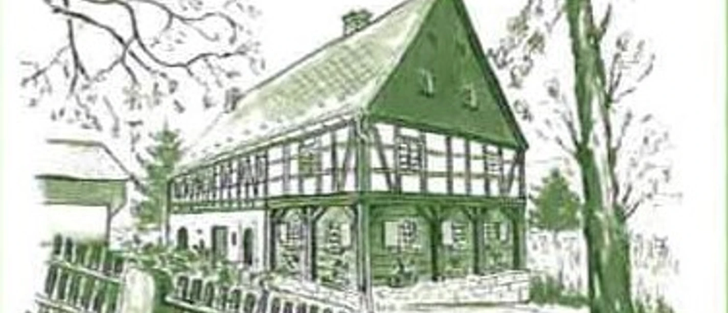Maienhof Kleingießhübel Fachwerkhaus im Grünen mit Spitzdach, großen Fenstern, umgeben von Bäumen und Holzzaun.