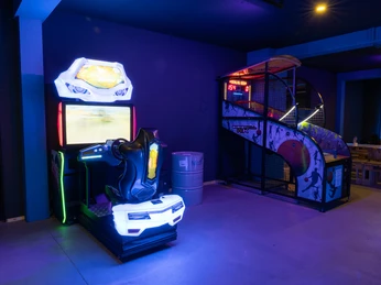 Arcade Spielhallengeräte in einem neonbeleuchteten Arcade-Raum.