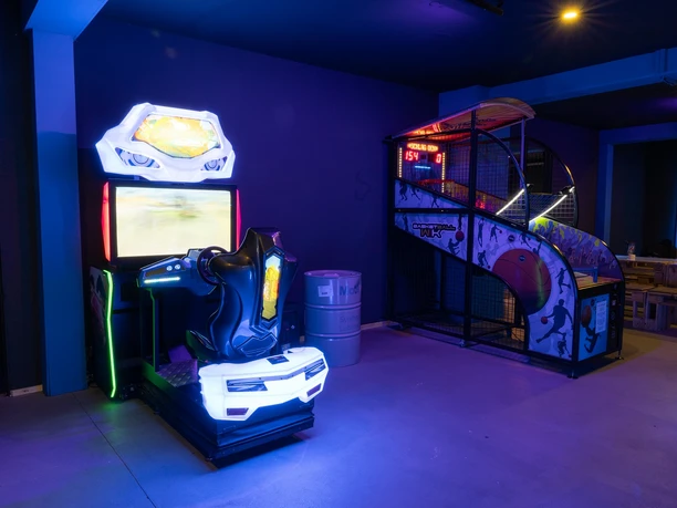 Arcade Spielhallengeräte in einem neonbeleuchteten Arcade-Raum.