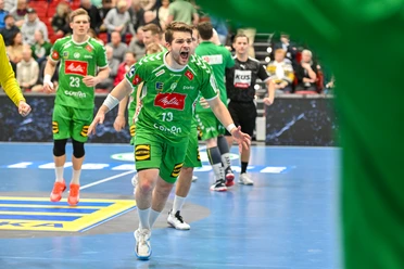GWD Minden - Spiel Ein Handballspieler von GWD Minden im grünen Trikot jubelt auf dem Spielfeld während eines Spiels.