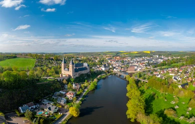 Luftaufnahme Schloss Rochlitz Drohnenaufnahme der Zwickauer Mulde mit dem imposanten Schloss Rochlitz und der Hängebrücke bei Zaßnitz im Frühjahr mit gelben Rapsfeldern in der Ferne, Mulderadweg, Lutherweg Sachsen