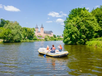 Schlauchbootfahren auf der Mulde - Aktiv in der Leipzig Region Drei Schlauchbootfahrer mit Rettungswesten und Paddel auf der Zwickauer Mulde, Schloss Rochlitz und die St. Petrikirche zu Rochlitz im Hintergrund, Freizeit, Aktiv