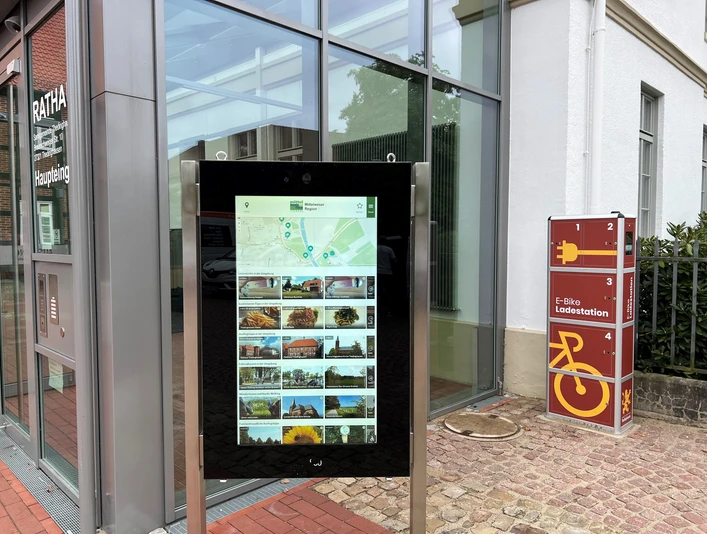 Infoterminal am Rathaus Thedinghausen Infoterminal vor dem Rathaus in Thedinghausen mit digitaler Karte und E-Bike-Ladestation rechts.