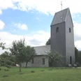 Windrather Kapelle, Velbert Historische Kapelle in Velbert mit steinverkleidetem Turm umgeben von grüner Wiese und Bäumen.