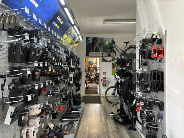 Bikers Point Fahrradladen von innen mit ausgestellten Zubehörteilen, Fahrrädern und einer dekorativen Wand.