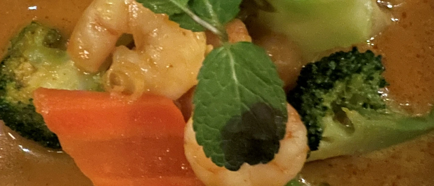 Chinesisches Gericht Ein farbenfrohes Gericht aus Garnelen und knackigem Gemüse in würziger, oranger Curry-Sauce.