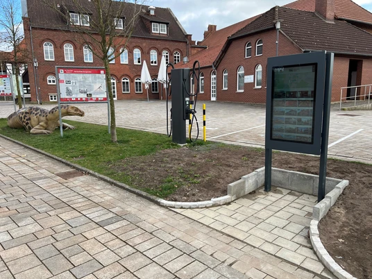 Infoterminal Rehburg Infoterminal in Rehburg auf gepflastertem Platz, mit Dinosauriermodell auf angrenzendem Rasen.