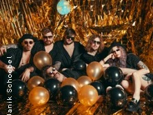 Sechs Personen in dunkler Kleidung, umgeben von schwarzen und goldenen Luftballons, vor einer goldenen Kulisse.