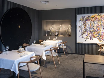 ox&klee Elegantes Restaurant mit modernen Kunstwerken, stilvollen Tischen und komfortablen Holzstühlen.Elegant restaurant with modern works of art, stylish tables and comfortable wooden chairs.