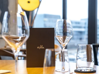 ox&klee Moderner Restauranttisch im "ox&klee" mit eleganter Menükarte und stilvollen Gläsern, Köln.Modern restaurant table in "ox&klee" with elegant menu card and stylish glasses, Cologne.