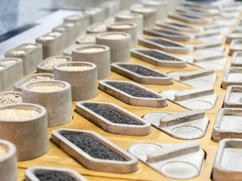 ox&klee A variety of spices and ingredients in concrete containers on wooden trays in a modern display.