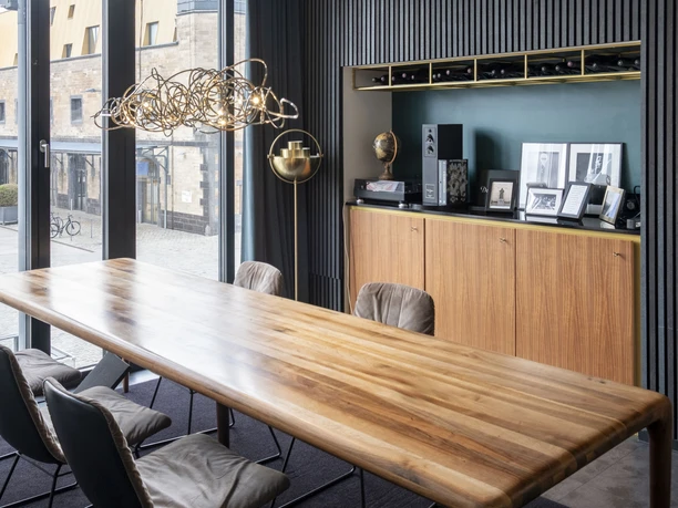 ox&klee Interior view of a modern conference room with wooden table, leather armchairs and stylish lighting.