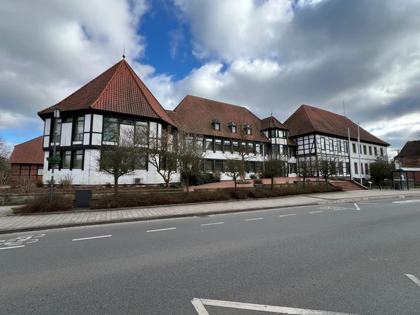 Fachwerk-Rathaus Rehburg mit markanten roten Dächern und symmetrischen Fenstern unter blauem Himmel.