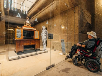 Ausstellung im Völkerschlachtdenkmal - Sehenswürdigkeiten in Leipzig Eine Rollstuhlfahrerin betrachtet ein Ausstellungsstück aus der Zeit Napoleons hinter einer Glasscheibe im Inneren des Völkerschlachtdenkmal, Sehenswürdigkeiten, Geschichte