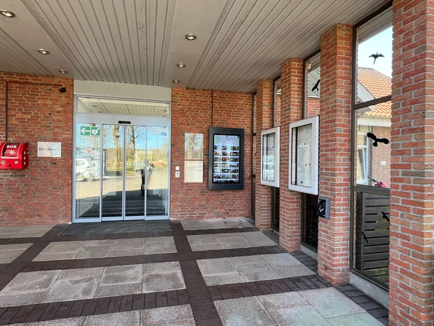 A modern information kiosk in Heemsen with clearly laid-out displays and a glass entrance door.