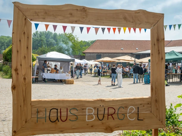 Bürgeler Hofmarkt Haus Bürgel Der Bürgeler Hofmarkt in Haus Bürgel bietet Stände, Besucher und eine hölzerne Umschlossumsicht.