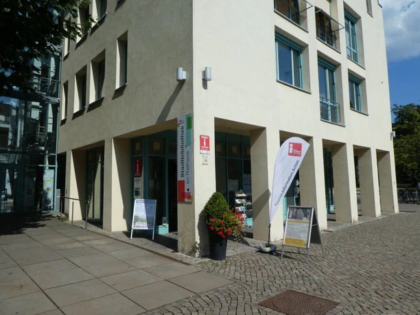Tourist Information Achim on a sunny day with information banner and shop windows.
