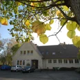Dorfgemeinschaftshaus in Alt-Espelkamp Das Dorfgemeinschaftshaus Alt-Espelkamp mit gelben Herbstblättern im Vordergrund auf einem Baumzweig.