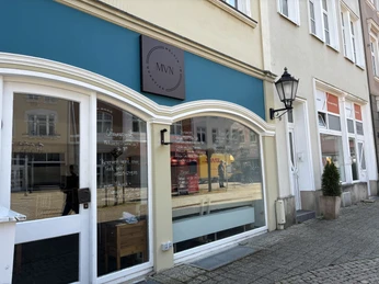 Herford--Melvin im Quatier-Pro Herford GmbH (69).jpeg Großes Schaufenster eines Cafés mit türkisfarbenem Vordach und stilvoller Außenbeschriftung.