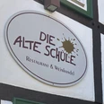 Herford-Die Alte Schule-Pro Herford GmbH (21).jpeg Das Schild der "Die Alte Schule" in Herford, ein Restaurant und Weinhandel, an Fachwerk.