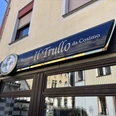 Außenansicht eines mittelgroßen, gelben Gebäudes mit "Ristorante Il Trullo da Cosimo" Schild.