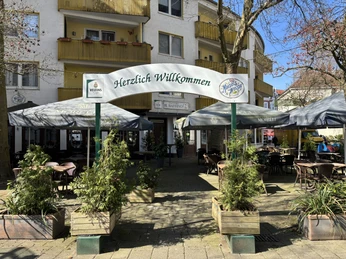 Herford-Trattoria il Baffino-Pro Herford GmbH (78).jpeg Der Eingang zur Trattoria il Baffino inmitten von Blumenkübeln und Sonnenschirmen.