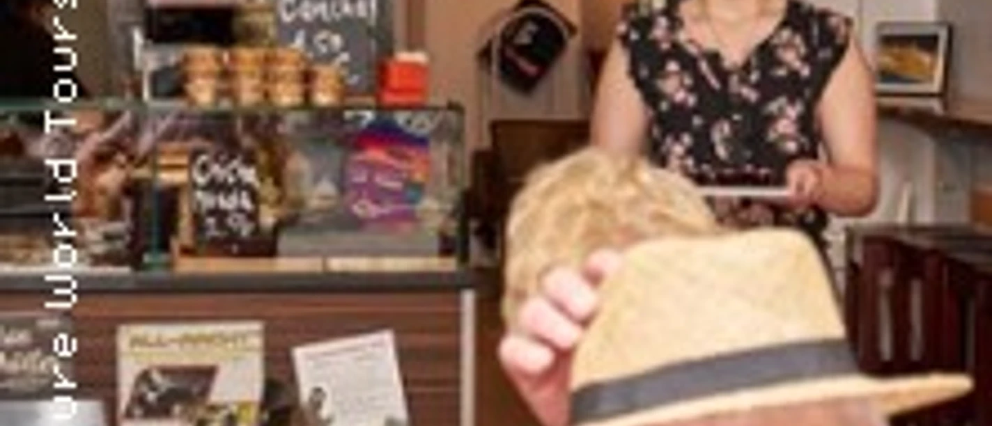 Gemütliches Café mit Menschen im Gespräch, holzgetäfelter Tresen im Hintergrund.