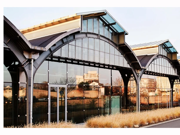 Design Post Köln Die Design Post Köln präsentiert sich als ein modern umgebauter Industriekomplex mit großen Bogenfenstern und einer Glasfassade. Die Architektur verbindet historische Elemente mit zeitgenössischer, klarer Linienführung.