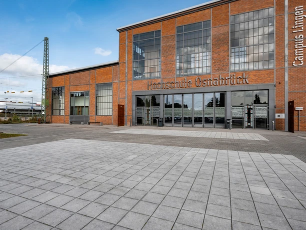 884_HS_OS_Campus_Lingen_Sep_2023.jpeg Backsteinbau mit großen Fensterfronten und Eingang des Campus Lingen der Hochschule Osnabrück