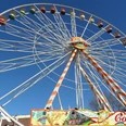 Volksfest auf der Freiheit - Pro Herford GmbH.JPG Riesenrad auf einem Volksfest vor blauem Himmel, bunte Gondeln und dekorative Details.