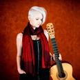 Stephanie-Jones-Gitarre-Pressefoto.jpg Stephanie Jones mit Gitarre vor rotem Hintergrund