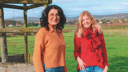 Ruzanna Shahinyan + Silke Domke.jpg Zwei Frauen, eine mit schwarzen Haaren und eine mit blonden, stehen lächelnd auf einer Wiese.