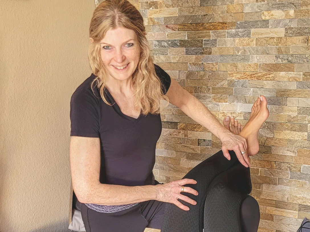 Sylke Domke Sylke Domke bei der professionellen Beinmassage in entspannter Umgebung, lächelnd zugewandt.