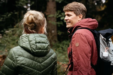 Wandern im Teutoburger Wald Ein Mann und eine Frau wandern in waldreicher Umgebung, tragen wetterfeste Kleidung.