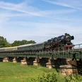 Eisenbahnmuseum Leipzig - Dampffahrten nach Kössern Eine Dampfbahn überquert bei ihrer sommerlichen Fahrt durch die Region Leipzig die Eisenbahnbrücke in Kössern