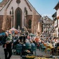 Frühjahrsmarkt Belebter Frühjahrsmarkt vor Kirche mit Karussell, Ständen und vielen Besucher:innen.