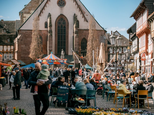 Frühjahrsmarkt Belebter Frühjahrsmarkt vor Kirche mit Karussell, Ständen und vielen Besucher:innen.