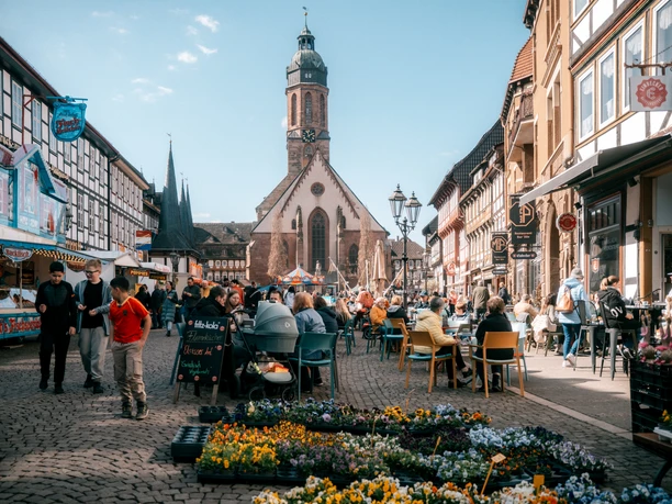 Frühjahrsmarkt Belebter Frühjahrsmarkt in Einbecks Altstadt mit Ständen, Blumen und Kirche im Hintergrund.