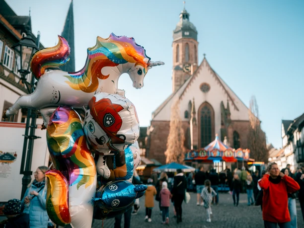 Frühjahrsmarkt Bunte Einhornballons vor Kirche und Karussell auf dem Frühjahrsmarkt in Einbeck.