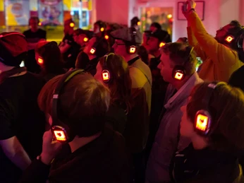 Modularfield Konzertbesucher tragen beleuchtete Kopfhörer im Modularfield-Shop, um ein immersives Hörerlebnis zu erleben.Concertgoers wear illuminated headphones in the Modularfield store for an immersive listening experience.