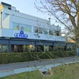 Ristorante La Perla Herford_Pro Herford GmbH.jpg Moderne weiße Gebäude Fassade des italienischen Restaurants La Perla mit verglaster Terrasse und Baum.
