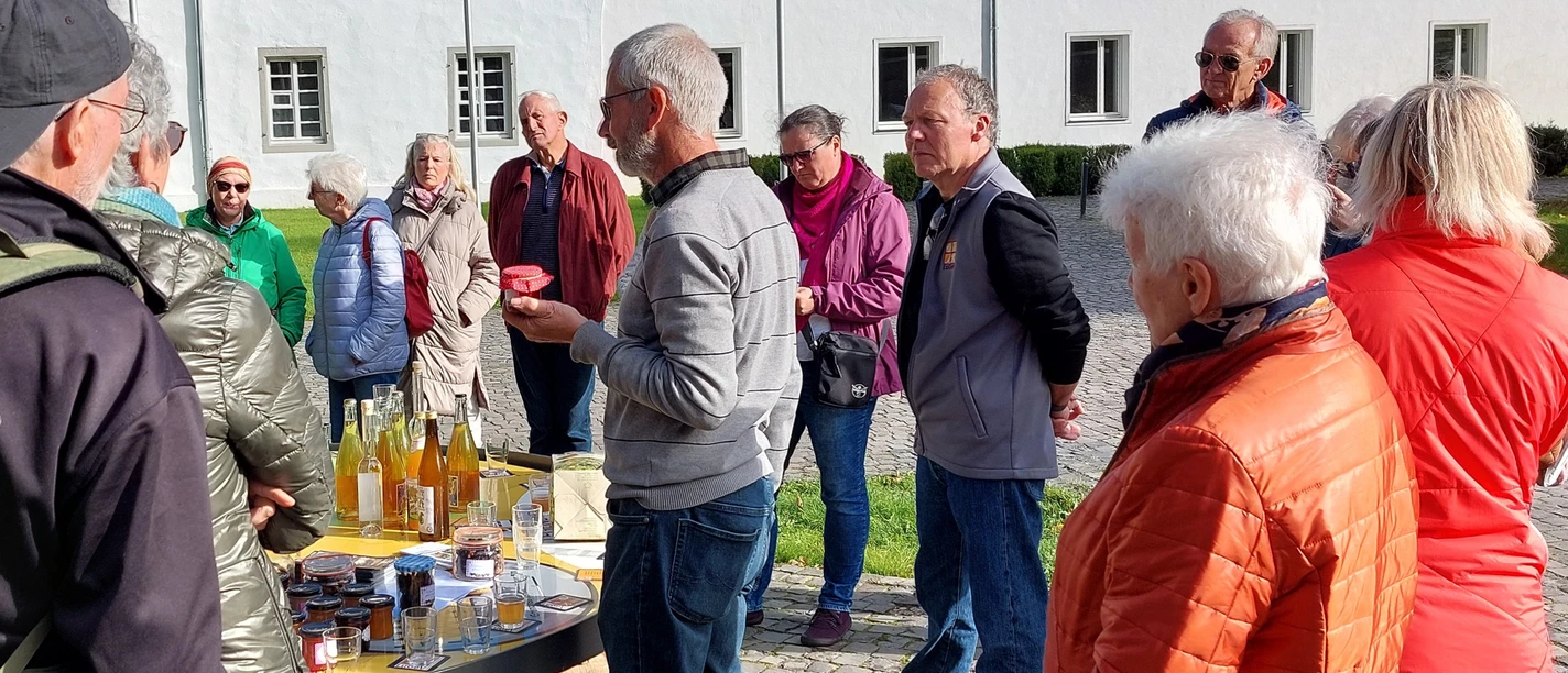 LuGeV-Führung Obst Gruppe älterer Menschen steht bei einer Verkostung von regionalen Produkten vor einem historischen Gebäude.