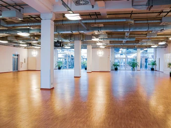 Schlossallee_5.jpg Heller, leerer Veranstaltungssaal mit großen Fenstern, Parkettboden und modernen Lüftungsrohren.</p>Bright, empty event hall with large windows, parquet flooring and modern ventilation ducts.</p> <p