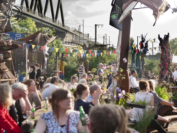 Odonischer Biergarten Menschen genießen geselliges Beisammensein im lebhaften Odonischer Biergarten unter bunten Wimpeln.