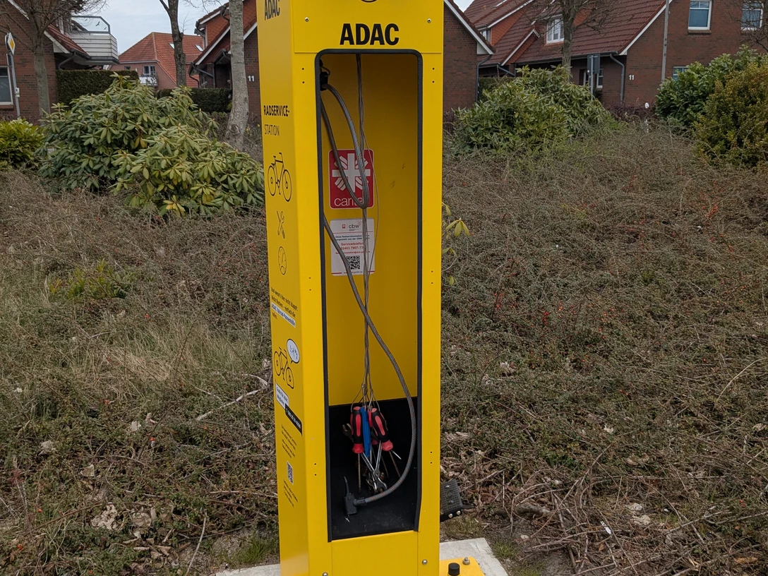 reparatursäule.werdum.jpg Gelbe Reparatursäule für Fahrräder mit Werkzeugen an langen Schnüren