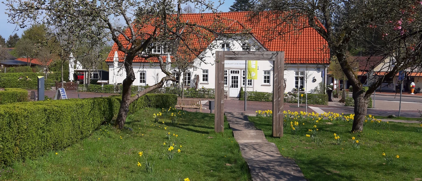 Blick aus dem Garten des alten Rathaus View over a blooming garden of the old town hall in Worpswede and the restaurant "Zum Hemberg" opposite.