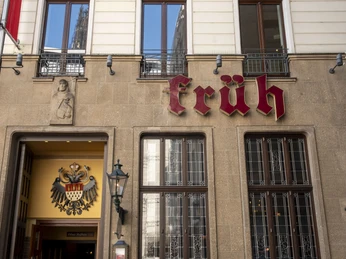Früh am Dom Außenansicht auf das Brauhaus mit großem markantem Brauhausschild. Exterior view of the brewery with a large distinctive brewery sign.