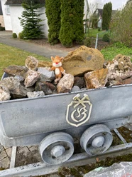Hörmusuem Bleiwäsche Ein Bergbauwagen voller Gesteinsbrocken und ein kleiner Stofffuchs darauf am Hörmuseum Bleiwäsche.